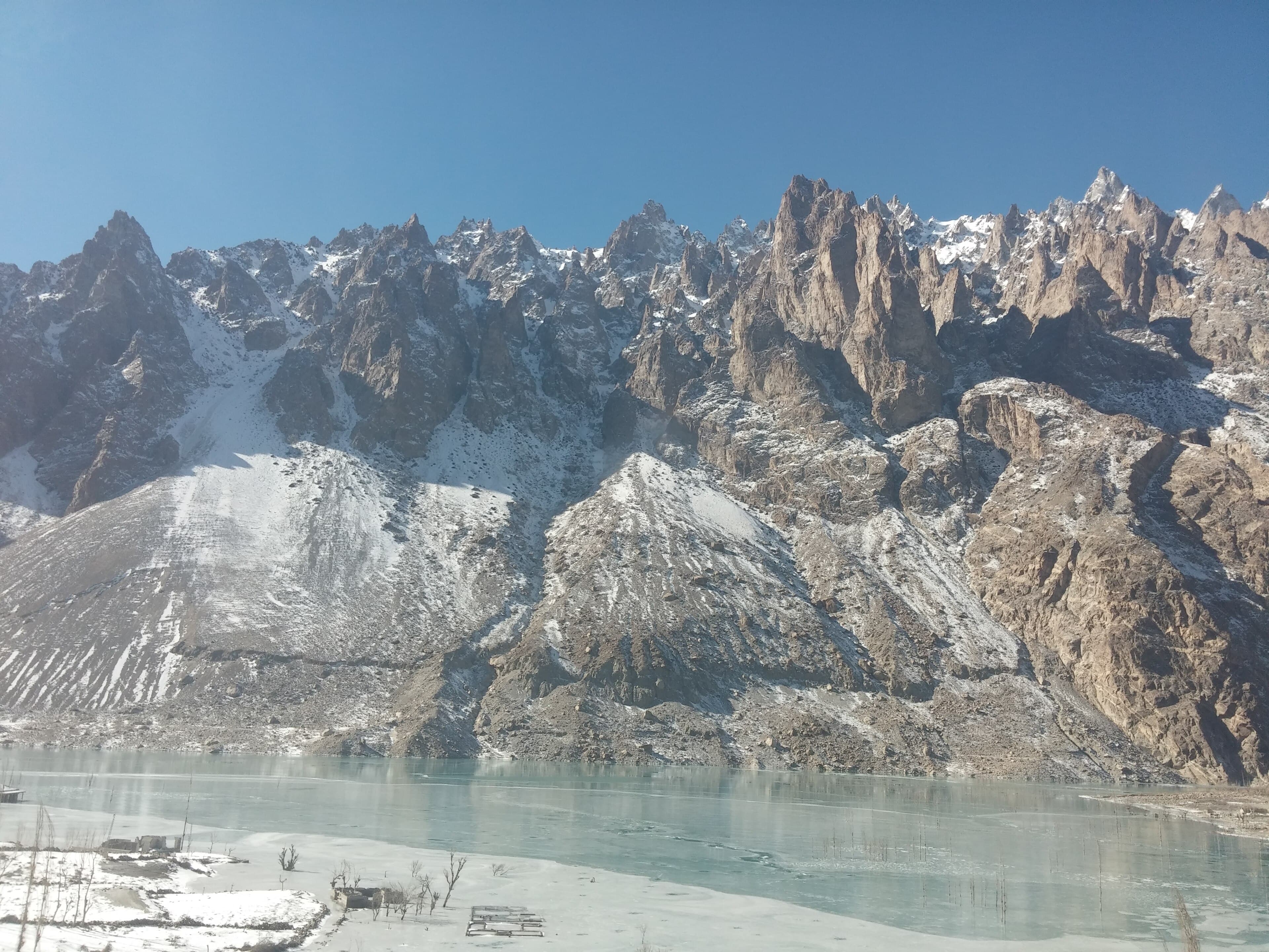 Snow-covered Hunza Valley in winter with Rakaposhi gleaming white above frozen terraced fields