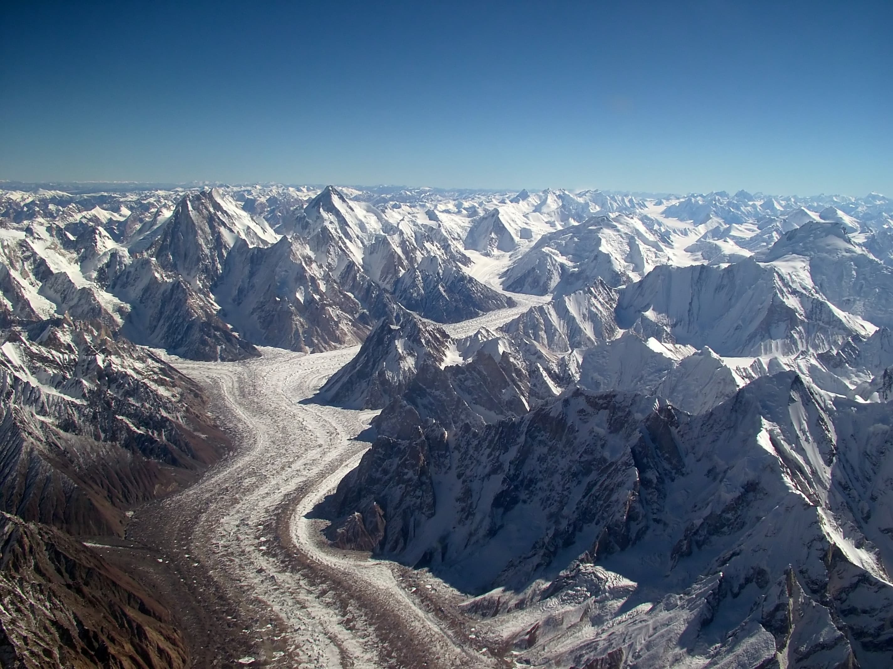 Trekkers on the Baltoro Glacier trail near Skardu, surrounded by Karakoram granite peaks