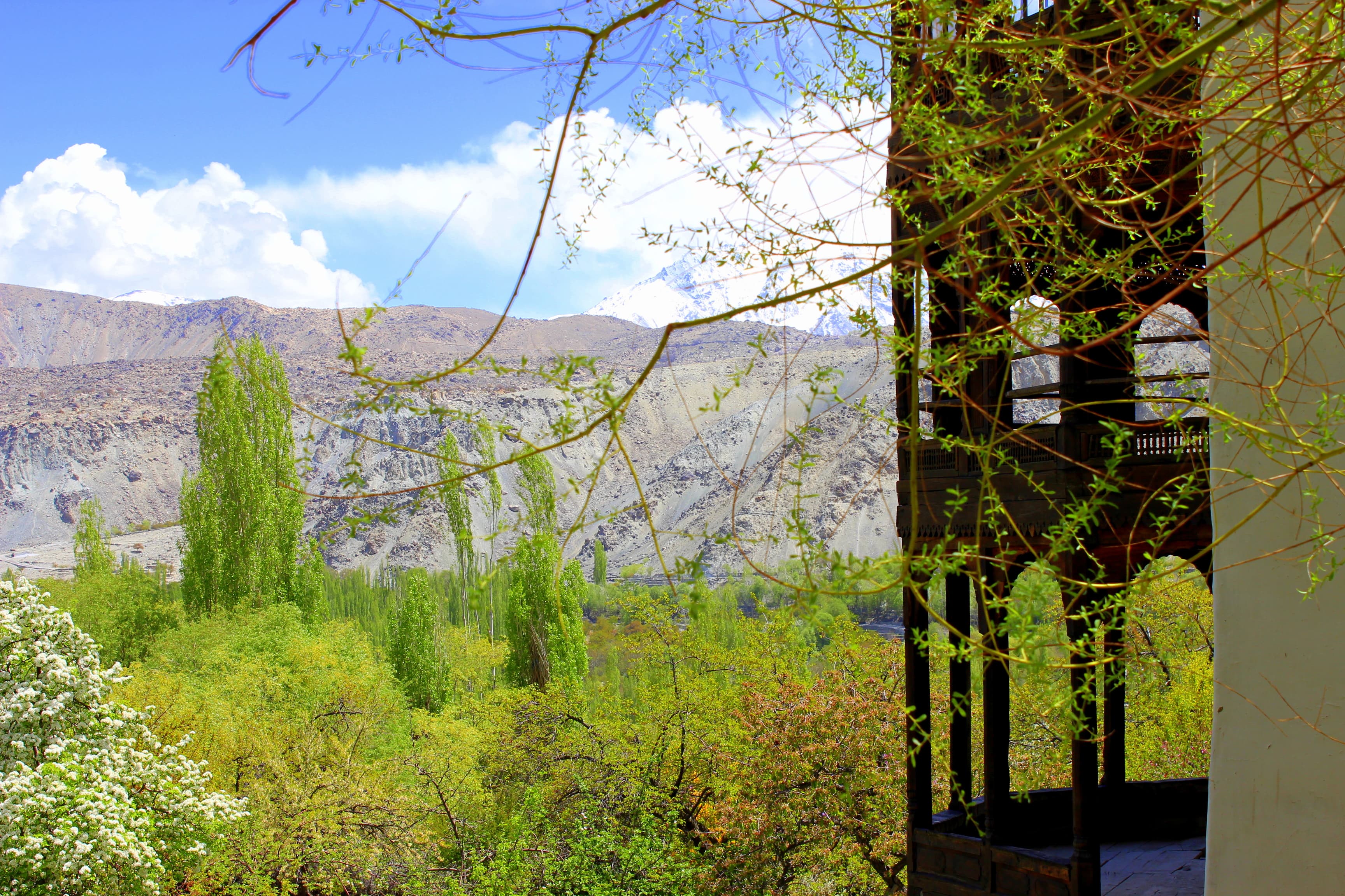 Khaplu Palace with terraced fields and Karakoram peaks behind